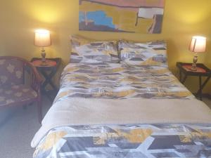 1 cama en un dormitorio con 2 lámparas en las mesas en The Loft Lynette's en Krugersdorp