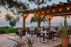 a restaurant with tables and chairs under a pergola at Hotel Paradou Mediterranee, BW Signature Collection by Best Western in Sausset-les-Pins