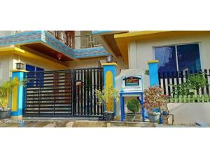 a house with a fence and potted plants in front of it at Twin AP Homes in Boracay