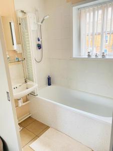 a bathroom with a white tub and a sink at The Mallards in Sleaford