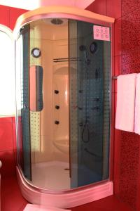 een douche in een badkamer met een glazen deur bij Theranda Boutique Hotel in Tirana