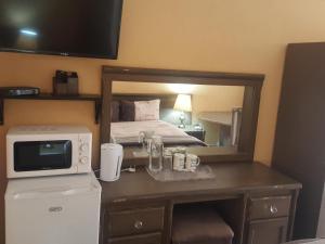 a hotel room with a bed and a microwave at The Loft Lynette's in Krugersdorp