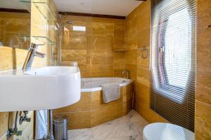 une salle de bain avec un lavabo et une baignoire dans l'établissement B&B Singel Suites, à Amsterdam 24 autres photos