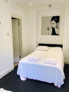 a bedroom with a white bed with two towels on it at Amhurst Hotel in London