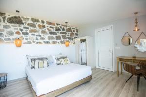 a bedroom with a bed, chair, and a wall clock at Adrakos Apartments (Adults Only) in Elounda