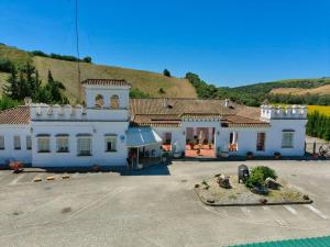 a large white building with a hill in the background at Hotel Arcos-Coruña in Arcos de la Frontera