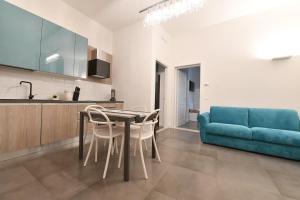 a living room with a blue couch and a table and chairs at Palazzo degli Stemmi in Todi