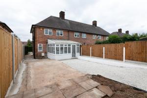 ein Haus mit einem Gewächshaus vor einem Zaun in der Unterkunft Nottingham Serviced Accommodations in Nottingham
