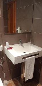 une salle de bain avec un lavabo blanc et un miroir dans l'établissement Hotel Arcos-Coruña, à Arcos de la Frontera