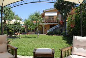 a garden with chairs and a yard with a house at Sweet Home & Apartments in Fontane Bianche