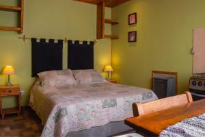 1 dormitorio con cama, mesa y fogones en Cabañas Costa del Percy en Trevelín