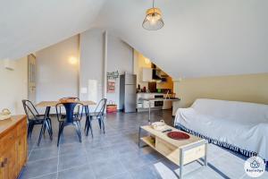 a living room with a bed and a table at T2 - Cantebazi 3 étoiles- plage de Saint-Leu in Saint-Leu