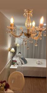 a chandelier is hanging over a bed in a room at Hotel da Praia in Vila Velha