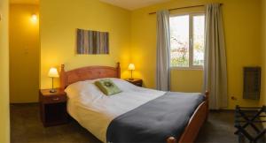 Un dormitorio con una cama grande y una ventana en Cabañas Costa del Percy en Trevelín