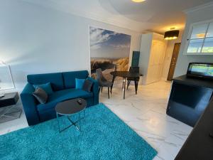 sala de estar con sofá azul y alfombra azul en EnergyApart 26, en Międzywodzie