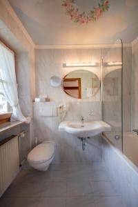 a bathroom with a sink and a toilet and a shower at Hotel Ziegleder in Rottach-Egern