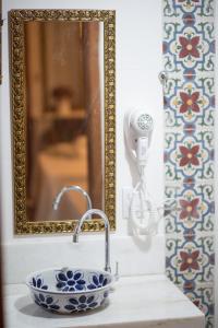 a bathroom sink with a mirror and a blue and white bowl at Hotel da Praia in Vila Velha