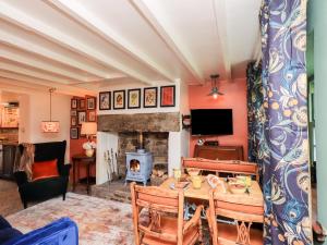 uma sala de estar com uma mesa e uma lareira em Bonny Bits Cottage em Alston