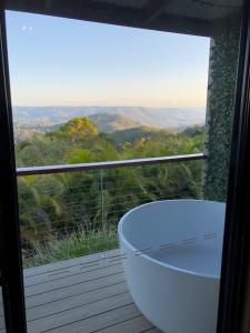 eine Badewanne auf dem Balkon mit Aussicht in der Unterkunft Maleny Luxury Cottages in Maleny