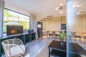 a living room with a television and a dining room at Apartament nadmorski z ogródkiem in Mechelinki