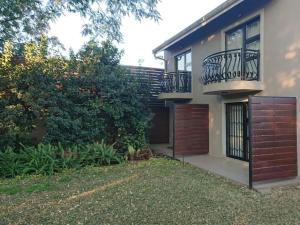 a house with two balconies and a yard at Unitas Guesthouse in Centurion