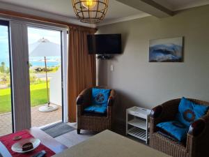 a living room with two chairs and a table and a window at Point Village Accommodation - Santos 6 in Mossel Bay