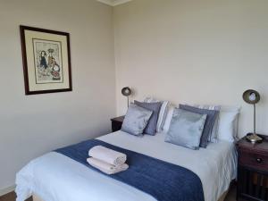 a bedroom with a white bed with blue pillows at Point Village Accommodation - Santos 6 in Mossel Bay