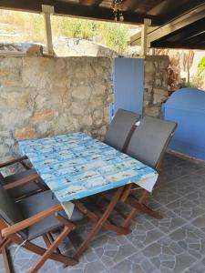 una mesa y sillas bajo una pared de piedra en Modern Two Floors Apartment With A Beautiful View, en Martinšćica