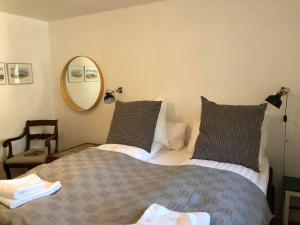 - une chambre avec un lit avec deux oreillers et un miroir dans l'établissement Tøndegården 2 rooms apartment, à Odense