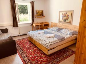 a bedroom with a bed and a table and a window at Schöneben Apartment Zollhaus 