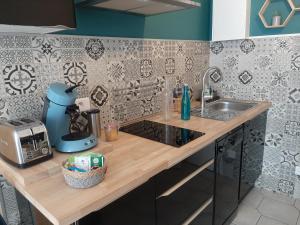 a kitchen with a sink and a counter top at Beau studio avec balcon in Bagnères-de-Bigorre