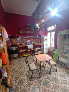 een keuken met een tafel en stoelen in een kamer bij CASA ARTIGAS Hostel in Cordoba