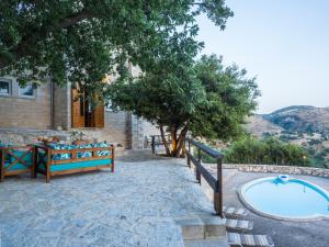 a patio with a swimming pool and a house at Stone Built Private villa Limeri with pool, BBQ & Shaded Patio in Áno Valsamóneron