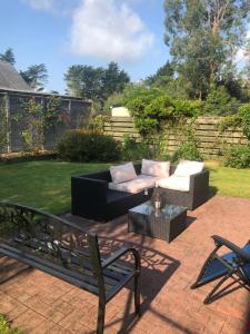 a patio with a couch and a table and a bench at Foxborough BnB in Droichead an Chaisleáin