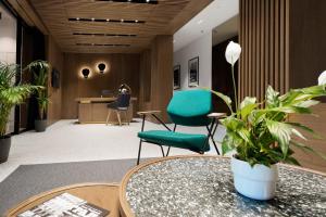 ベオグラードにあるDominic Smart & Luxury Suites - Editionの緑の椅子とテーブルのあるオフィス