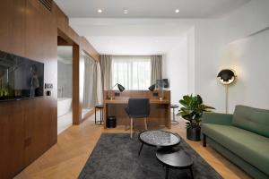 ベオグラードにあるDominic Smart & Luxury Suites - Editionのリビングルーム(緑のソファ、デスク付)