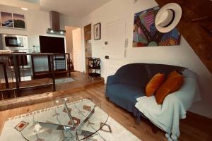 ein Wohnzimmer mit einem blauen Sofa und einem Tisch in der Unterkunft Brive centre, superb appartement en face du Marché Primé in Brive-la-Gaillarde