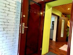 プシュキンスキエ・ゴリにあるGuest houseのレンガ造りの壁の部屋の赤いドア