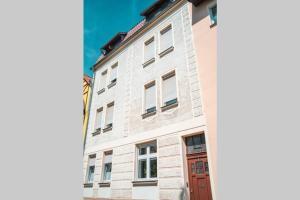 um edifício de tijolos brancos com uma porta vermelha em Liebevoll sanierte, großzügige Stadtwohnung, 70 qm em Quedlinburg