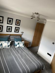 a bedroom with a bed with blue and white pillows at Burry Port Harbour Apartment in Burry Port