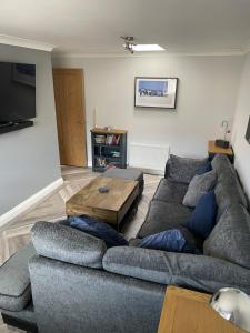 uma sala de estar com um sofá e uma mesa de centro em Burry Port Harbour Apartment em Burry Port