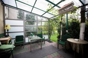 a conservatory with a table and chairs and a table and windows at Akacja Pokoje Gościnne in Krakow