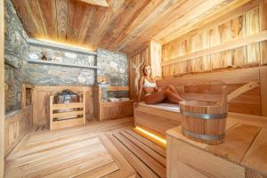 a woman sitting in a wooden sauna at VillAmour Boutique Hotel & SPA in La Salle