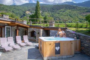 una mujer sentada en un jacuzzi en la parte superior de una casa en VillAmour Boutique Hotel & SPA, en La Salle