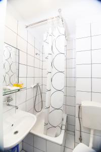 a white bathroom with a sink and a mirror at Akacja Pokoje Gościnne in Kraków