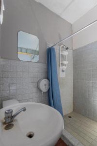 uma casa de banho com um lavatório e uma cortina de chuveiro azul em Hostel the pod 33 em Cidade do Panamá mais 37 fotografias