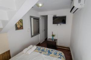 a bedroom with a bed and a tv on the wall at Hostel the pod 33 in Panama City