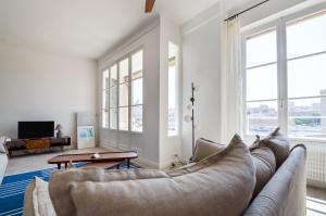 - un salon avec un canapé et une télévision dans l'établissement MASSILIA BLUE - Grand appartement refait à neuf avec vue sur le Vieux Port, à Marseille