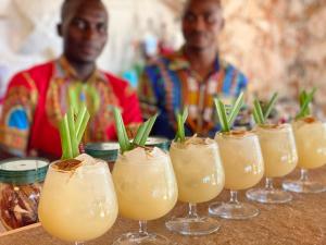 two men standing in front of a row of drinks at Palumboreef Beach Resort in Uroa