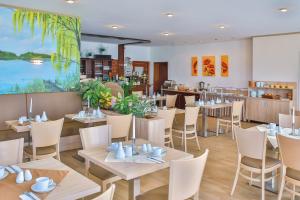 un restaurante con mesas y sillas y una gran ventana en Ferienanlage - Zum See en Plau am See